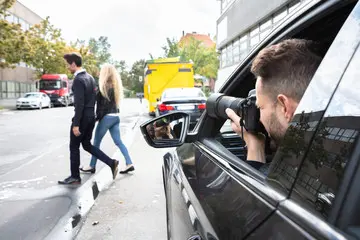A man taking pictures of people walking on the street